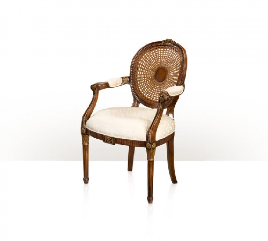 A hand carved and gilt armchair with a caned spoon back